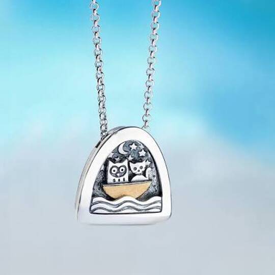 Silver pendant necklace with owl and crescent moon design above water waves